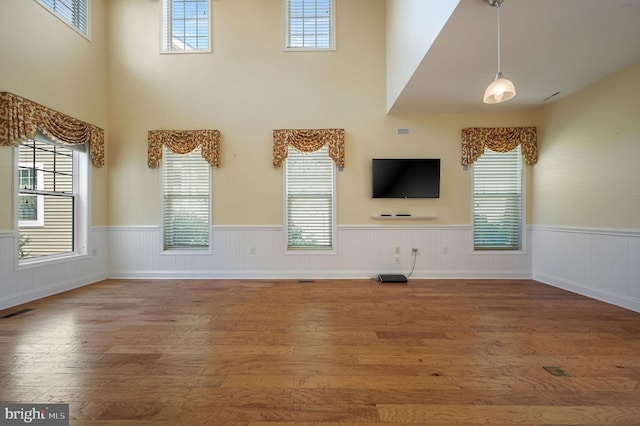 105 Arch St, Milton, DE 19968 - unfurnished living room with visible vents, a wainscoted wall, and wood finished floors