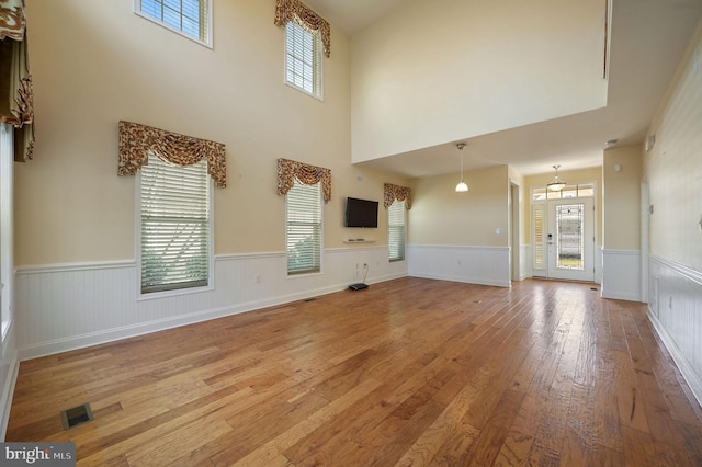 105 Arch St, Milton, DE 19968 - unfurnished living room featuring a wealth of natural light, visible vents, hardwood / wood-style floors, and a wainscoted wall