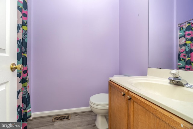 bathroom with visible vents, wood finished floors, baseboards, vanity, and toilet