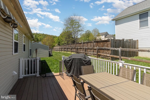 wooden deck with fence, outdoor dining space, and a yard