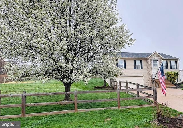 view of front of house featuring a garage, fence, a front yard, and concrete driveway