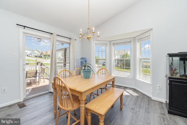 dining room featuring baseboards, a chandelier, wood finished floors, and vaulted ceiling