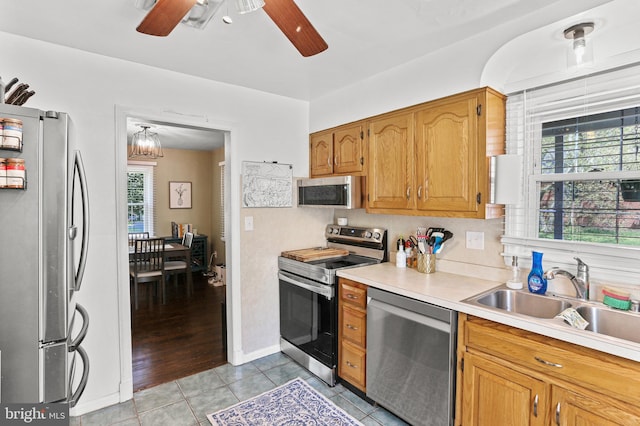 kitchen featuring a ceiling fan, a sink, light tile patterned floors, light countertops, and appliances with stainless steel finishes