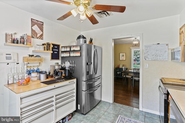 kitchen with light tile patterned flooring, baseboards, visible vents, a ceiling fan, and appliances with stainless steel finishes