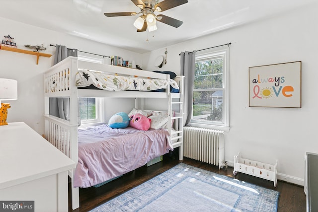 bedroom featuring baseboards, a ceiling fan, wood finished floors, and radiator