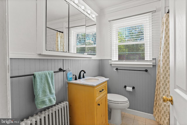 bathroom with a wainscoted wall, toilet, radiator heating unit, tile patterned flooring, and crown molding