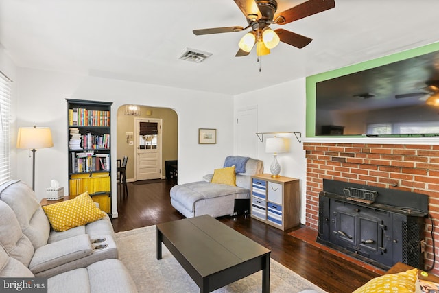 living area with wood finished floors, visible vents, arched walkways, and ceiling fan