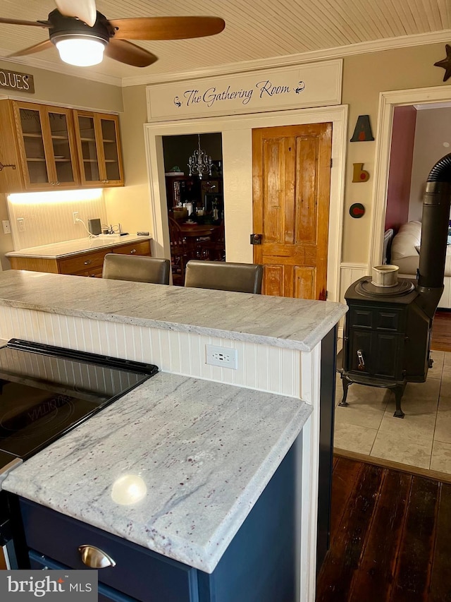 1671 Fravel Rd, Woodstock, VA 22664 - kitchen featuring crown molding, dark wood finished floors, a ceiling fan, glass insert cabinets, and light stone counters