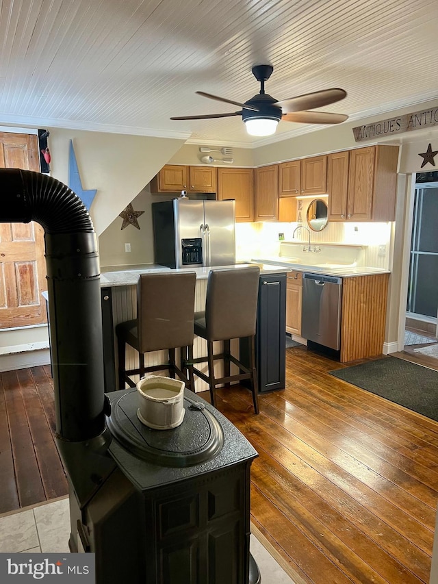 1671 Fravel Rd, Woodstock, VA 22664 - kitchen with appliances with stainless steel finishes, ceiling fan, a breakfast bar, light countertops, and hardwood / wood-style floors