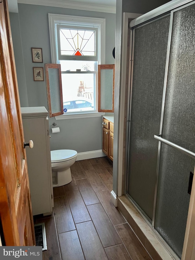 1671 Fravel Rd, Woodstock, VA 22664 - bathroom featuring wood finished floors, a shower stall, vanity, toilet, and ornamental molding