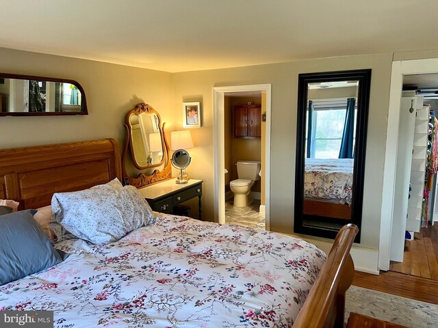 1671 Fravel Rd, Woodstock, VA 22664 - bedroom with wood finished floors, ensuite bath, and baseboards