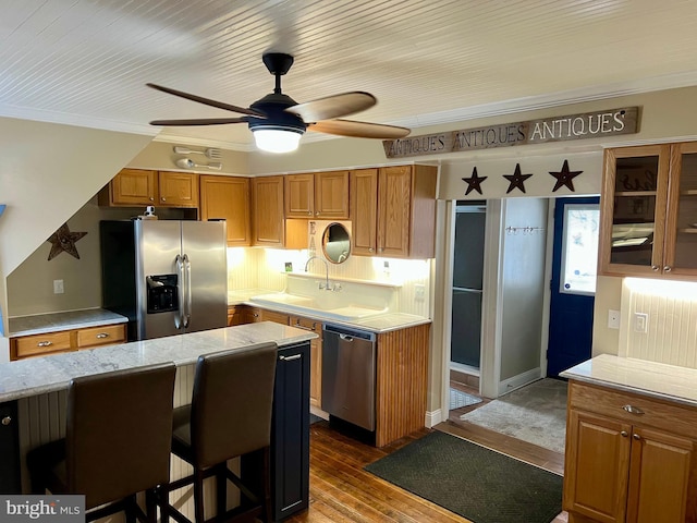1671 Fravel Rd, Woodstock, VA 22664 - kitchen with appliances with stainless steel finishes, a sink, a ceiling fan, brown cabinets, and a kitchen bar