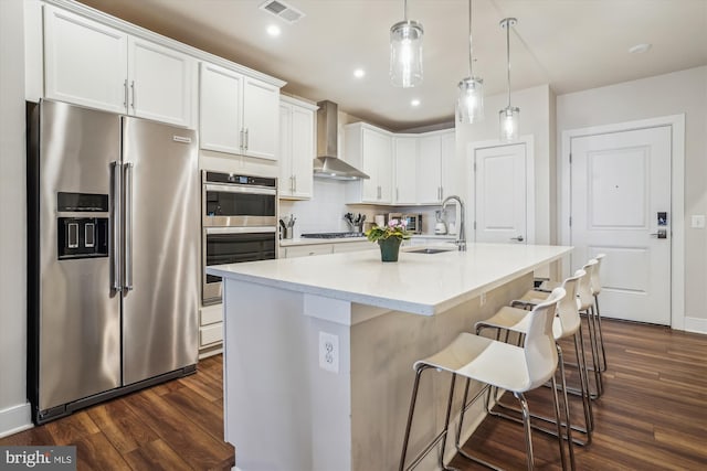 102 Saint Ives Pl Unit 209, National Harbor, MD 20745 - kitchen featuring white cabinets, visible vents, wall chimney exhaust hood, stainless steel appliances, and a sink
