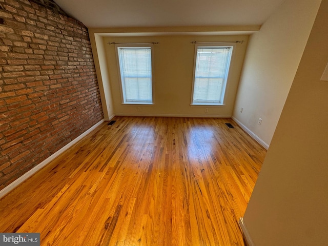 1637 Fleet St, Baltimore, MD 21231 - empty room featuring brick wall, baseboards, visible vents, and a wealth of natural light