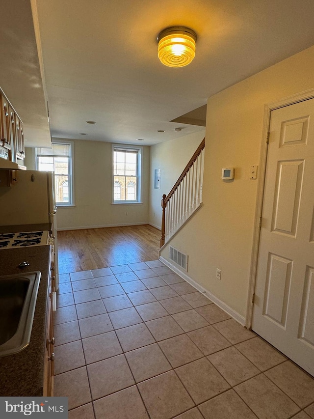 1637 Fleet St, Baltimore, MD 21231 - interior space with light tile patterned floors, baseboards, visible vents, and stairs