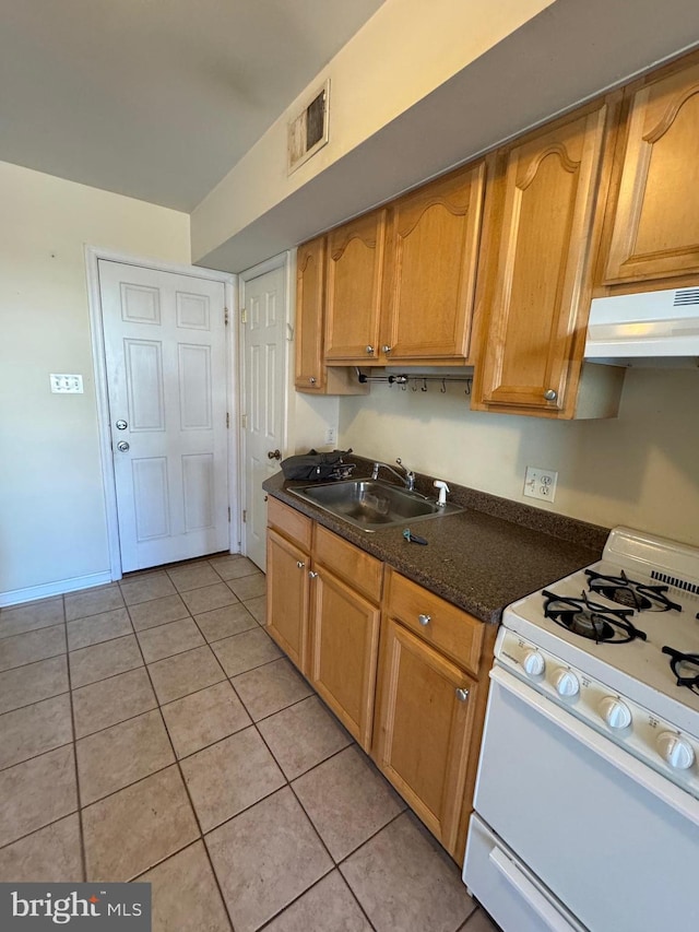 1637 Fleet St, Baltimore, MD 21231 - kitchen with visible vents, a sink, under cabinet range hood, white range with gas stovetop, and light tile patterned flooring