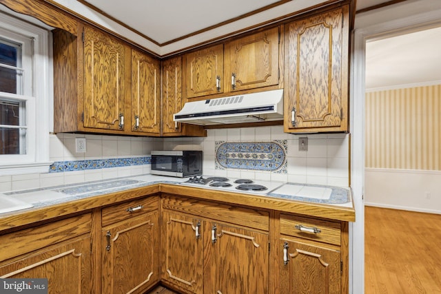 5936 River Dr, Lorton, VA 22079 - kitchen with extractor fan, tasteful backsplash, crown molding, brown cabinets, and light wood-style flooring