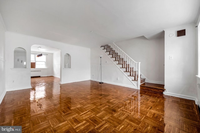 6846 Radbourne Rd, Upper Darby, PA 19082 - unfurnished living room featuring stairway, radiator heating unit, baseboards, visible vents, and arched walkways