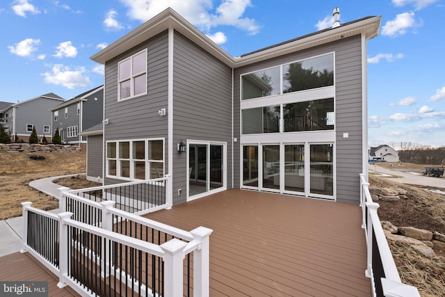 back of property featuring a wooden deck and a residential view