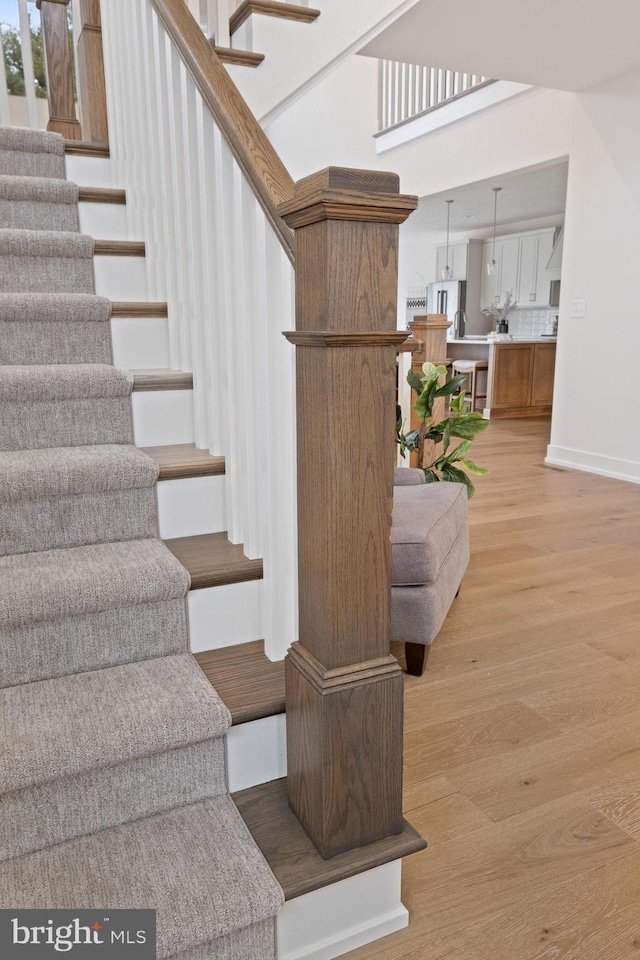 staircase with baseboards and wood finished floors