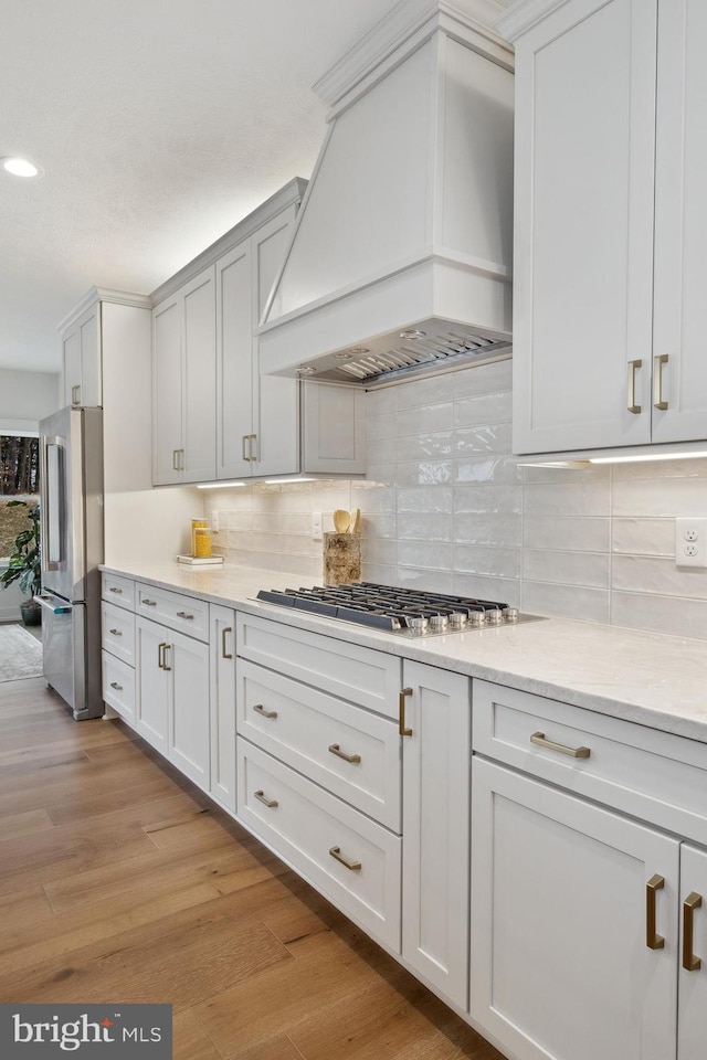 kitchen featuring recessed lighting, tasteful backsplash, appliances with stainless steel finishes, and custom range hood