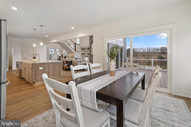 dining area featuring a wealth of natural light, stairway, recessed lighting, and light wood-type flooring