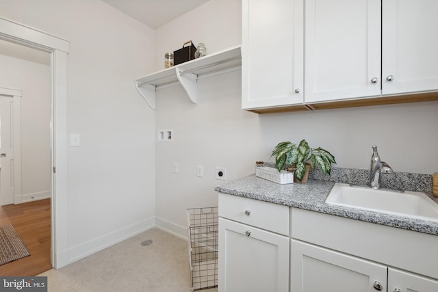 laundry area featuring baseboards, hookup for a washing machine, a sink, cabinet space, and electric dryer hookup
