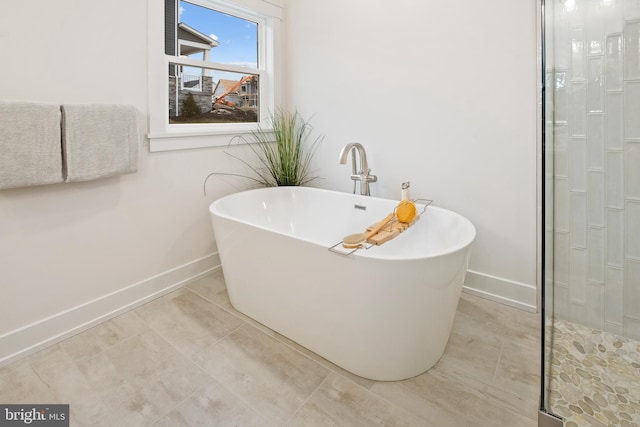 full bath featuring a soaking tub, baseboards, a shower stall, and tile patterned floors