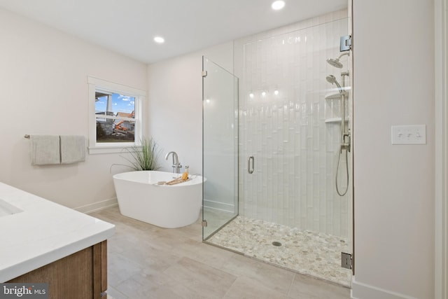 full bath with a stall shower, recessed lighting, vanity, and a freestanding tub