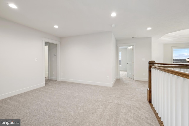 empty room featuring light colored carpet, baseboards, and recessed lighting