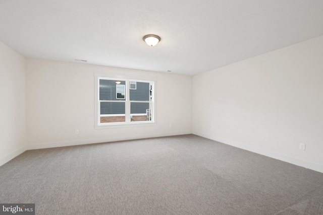 unfurnished room with baseboards and carpet flooring