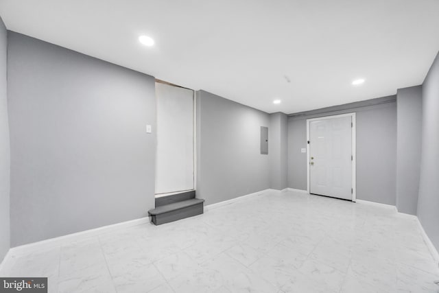 finished basement featuring baseboards, marble finish floor, recessed lighting, and electric panel