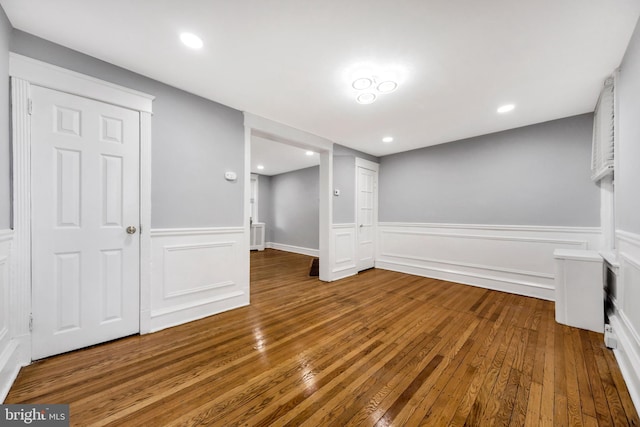 below grade area featuring wainscoting, recessed lighting, and wood-type flooring