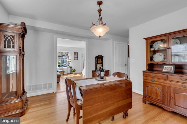 dining area featuring visible vents, baseboards, and light wood-style floors