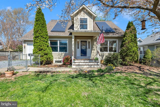view of front facade featuring fence, a front yard, solar panels, and a gate