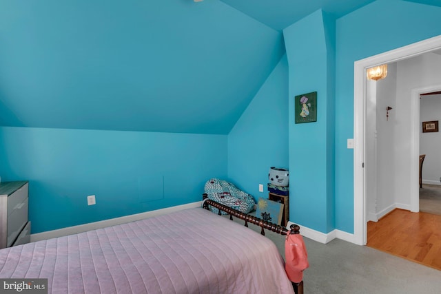 carpeted bedroom featuring baseboards and lofted ceiling