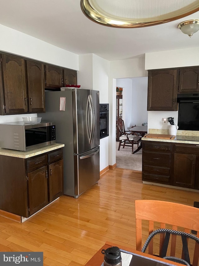 24 Elm Dr, Hightstown, NJ 08520 - kitchen featuring dark brown cabinetry, light wood-type flooring, light countertops, under cabinet range hood, and appliances with stainless steel finishes