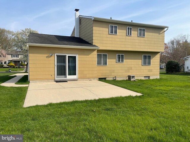 24 Elm Dr, Hightstown, NJ 08520 - back of property with a yard, a patio area, a chimney, and a shingled roof