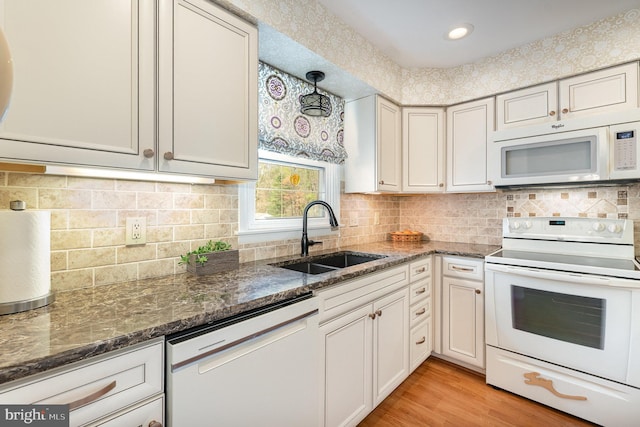 6 Dewberry Way, Bel Air, MD 21014 - kitchen with dark stone countertops, a sink, white appliances, light wood-style floors, and backsplash