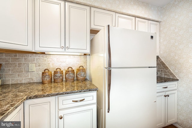 6 Dewberry Way, Bel Air, MD 21014 - kitchen with dark stone countertops, freestanding refrigerator, white cabinetry, and wallpapered walls