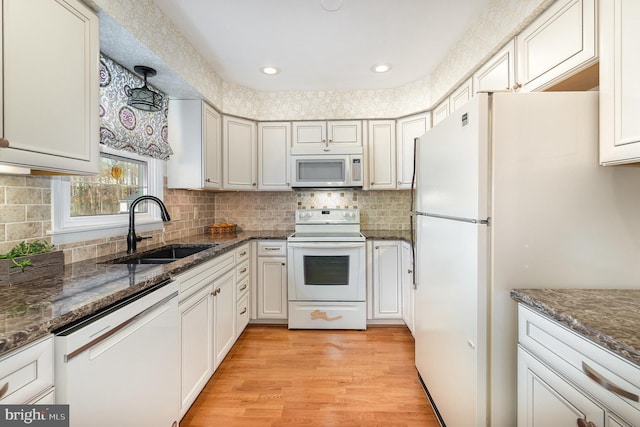 6 Dewberry Way, Bel Air, MD 21014 - kitchen featuring light wood-style floors, dark stone counters, white appliances, a sink, and backsplash