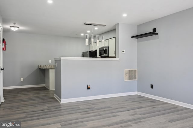 unfurnished room featuring baseboards, wood finished floors, visible vents, and recessed lighting
