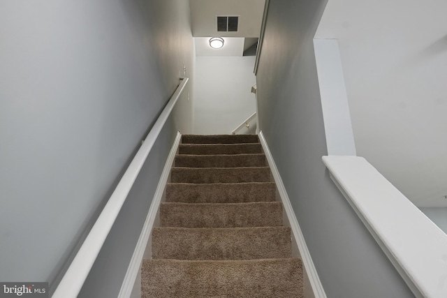stairs with visible vents and carpet flooring