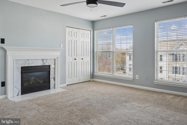 unfurnished living room featuring baseboards, a ceiling fan, and plenty of natural light