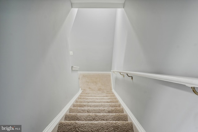 staircase with baseboards and carpet flooring