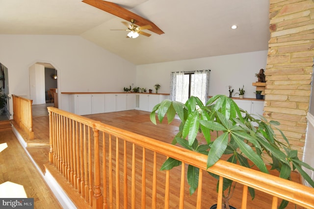 interior space featuring a wainscoted wall, ceiling fan, light wood-style floors, and vaulted ceiling