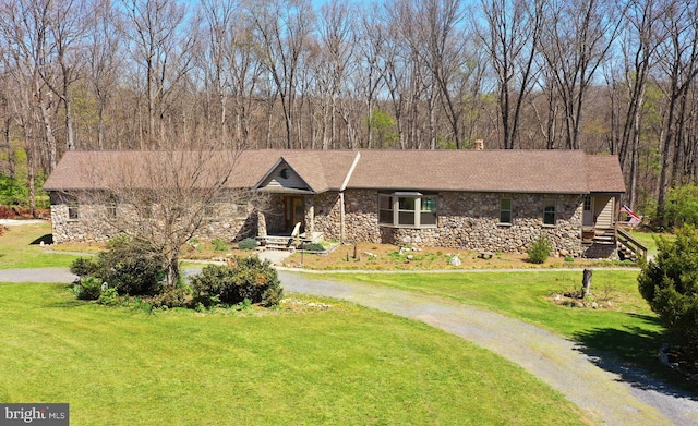 view of front of house with a front yard and stone siding