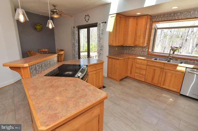 kitchen featuring a ceiling fan, stainless steel appliances, a healthy amount of sunlight, and a sink