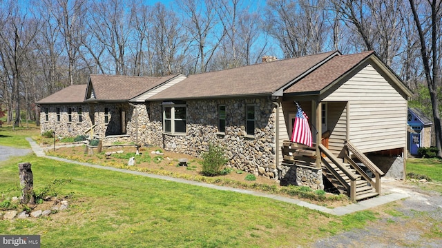 ranch-style home with stone siding, a front lawn, and roof with shingles