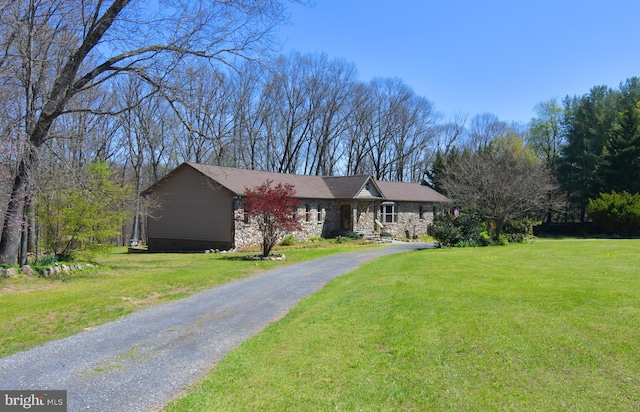 ranch-style house featuring aphalt driveway, a front yard, and stone siding